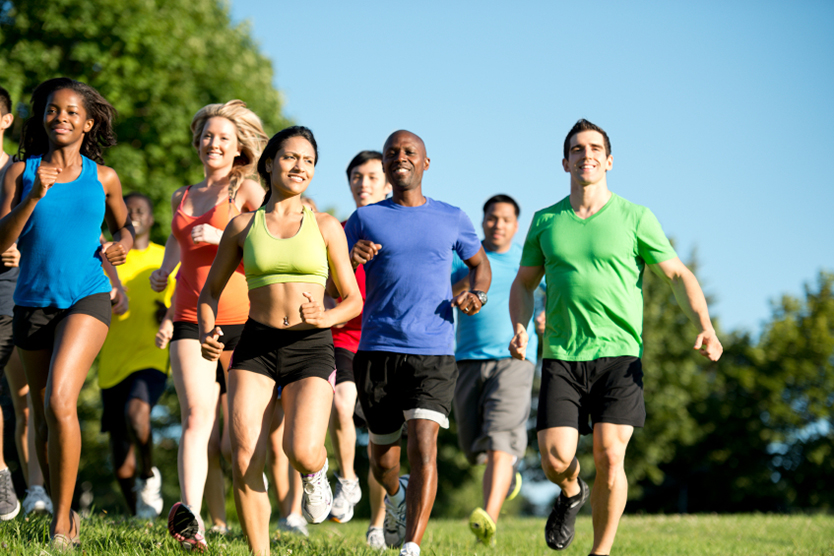 Eine Menschengruppe joggt durch den Park, symbolisiert Branchenfokus Sportwirtschaft; Quelle: istockphoto.com/CEFutcher