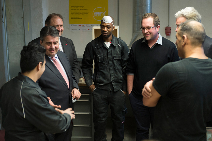 Federal Minister Sigmar Gabriel (2nd from left), ZDH-President Hans Peter Wollseifer (3rd from left) and the president of the Berlin Chamber of Crafts, Stephan Schwarz (2nd from right) during a visit of a training workshop for refugees in Berlin