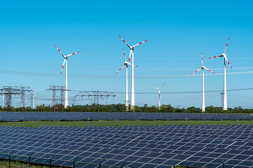 Panneaux solaires, éoliennes et poteaux électriques au sujet de la transition énergétique