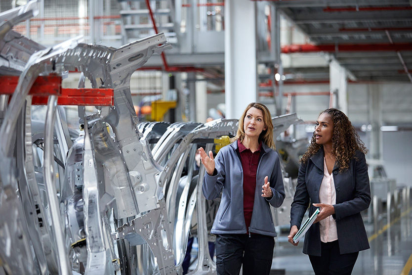Deux ingénieurs parlent dans une usine automobile
